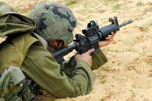 An Israeli defense forces soldier dressed in uniform aims his M16 rifle while on duty