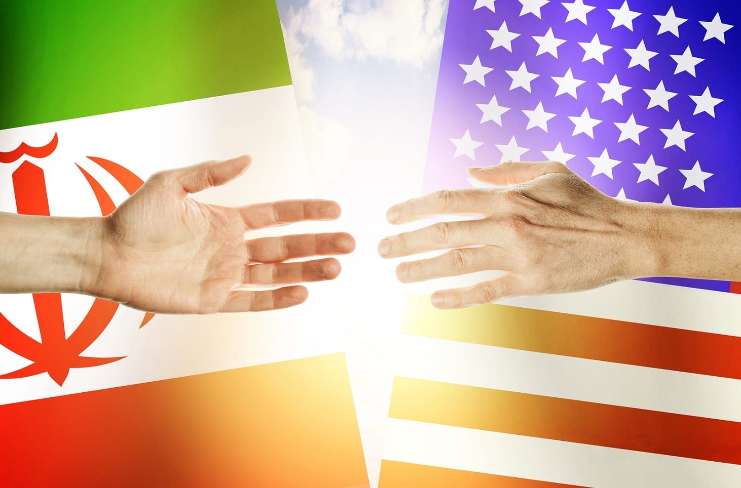 Two hands stretch towards each other against the background. Hands people against the backdrop flags USA and Iran