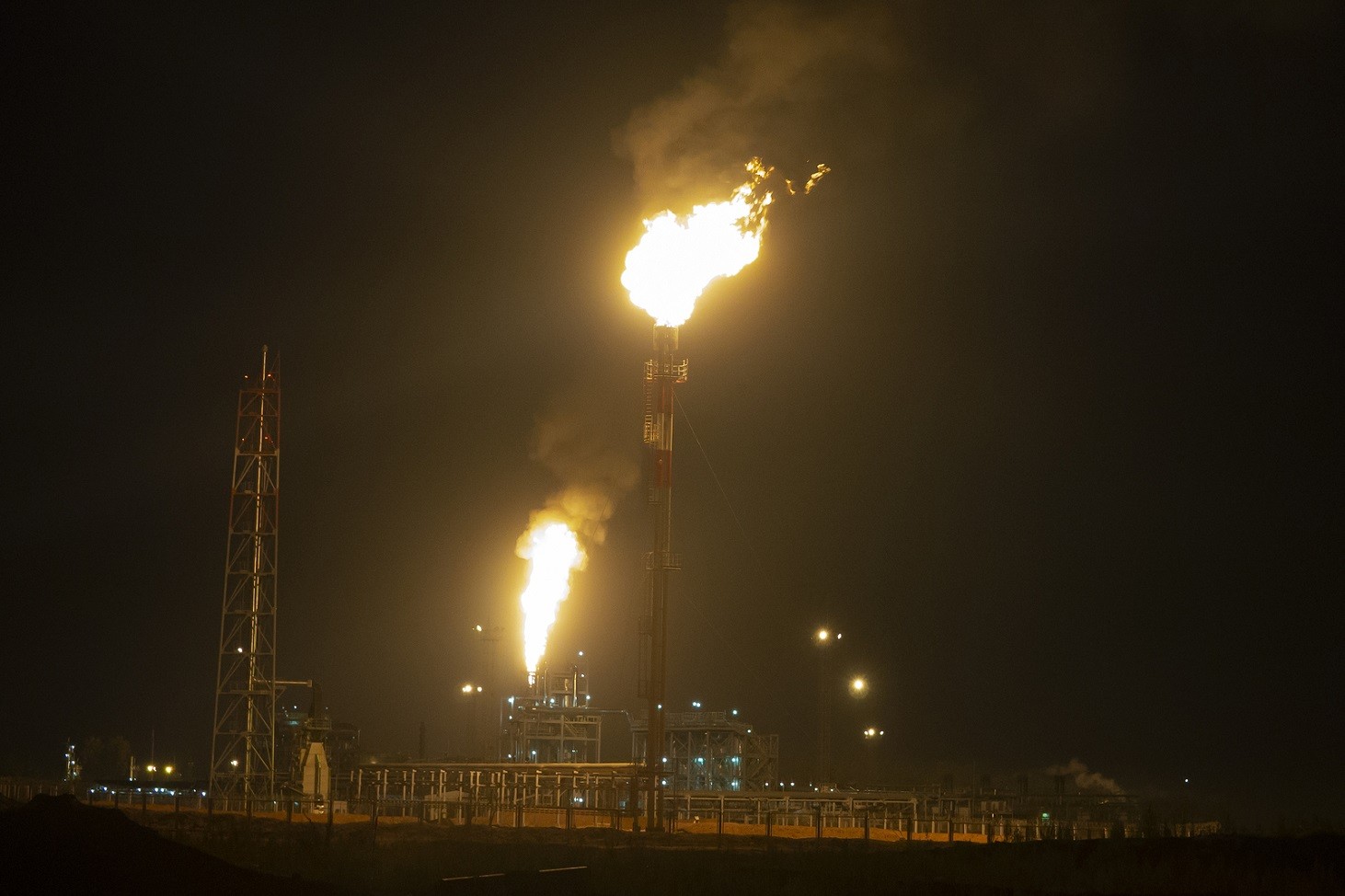 Oil Refinery At Night Creating A Huge Smoke Cloud With Reflectio