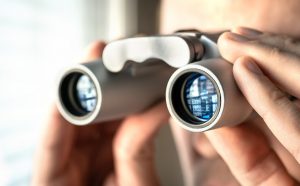 Man watching out the window with binoculars...