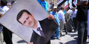 Protestor holding a photo of Assad