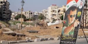 Homs, Syria - August 25, 2021: Poster of Bashar al-Assad in destroyed city center after Syria war.