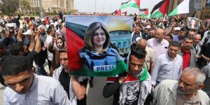 Students carry a mock coffin as they hold a symbolic funeral for slain Al Jazeera journalist Shireen Abu Akleh, at al-Azhar University in Gaza,
