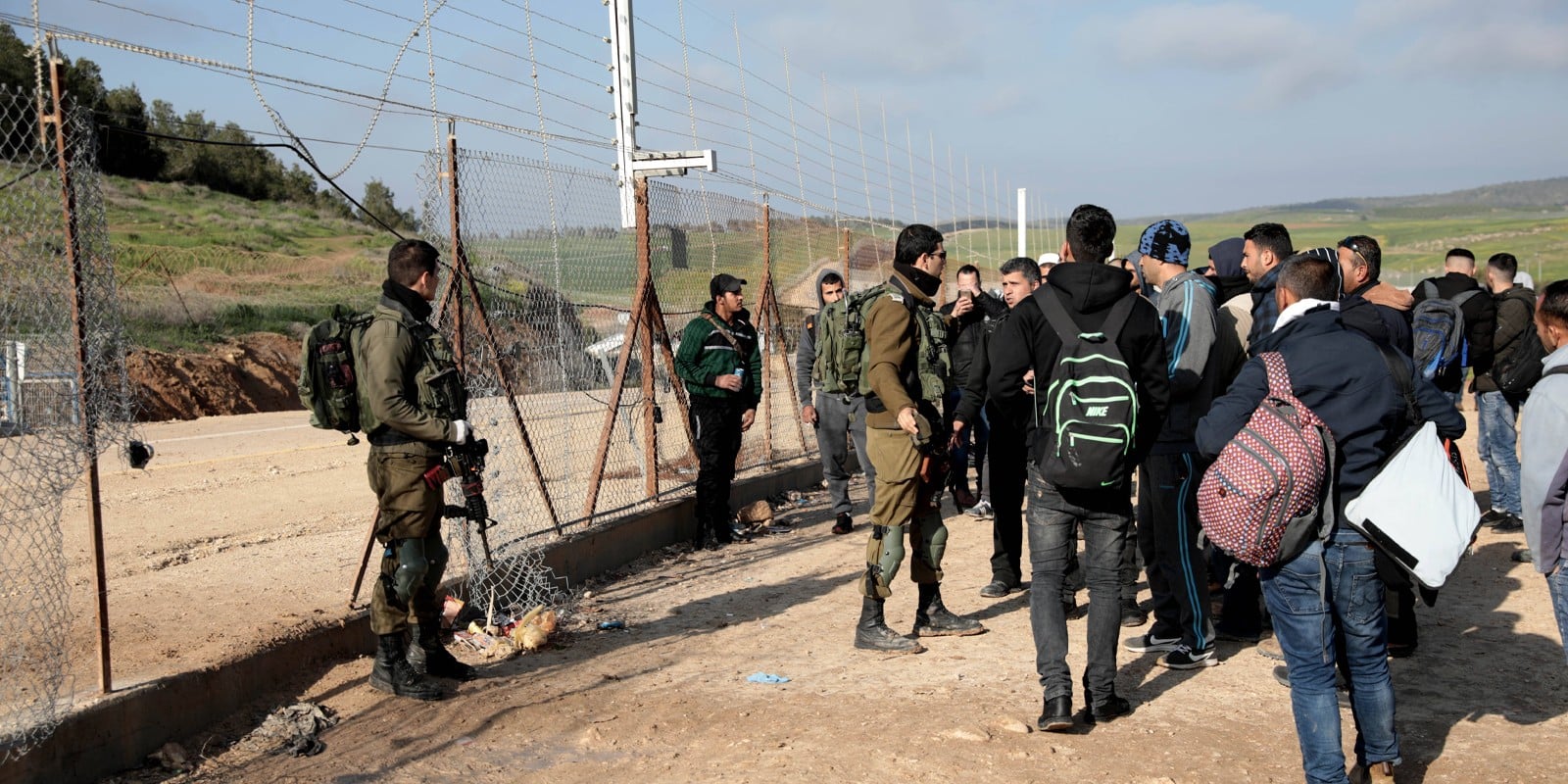 Palestinian workers try to enter Israel through a checkpoint between the West Bank city of Hebron and Beersheva.