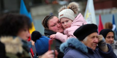 A woman holds a girl during a commemorative event held in remembrance of the fallen Ukrainian defenders at the Lychakiv Cemetery on the Day of the Ukrainian Armed Forces of Ukraine, Lviv, western Ukraine