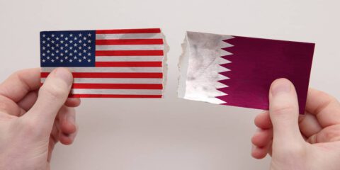 Photo usa and qatar paper flags ripped apart political relationship concept.
