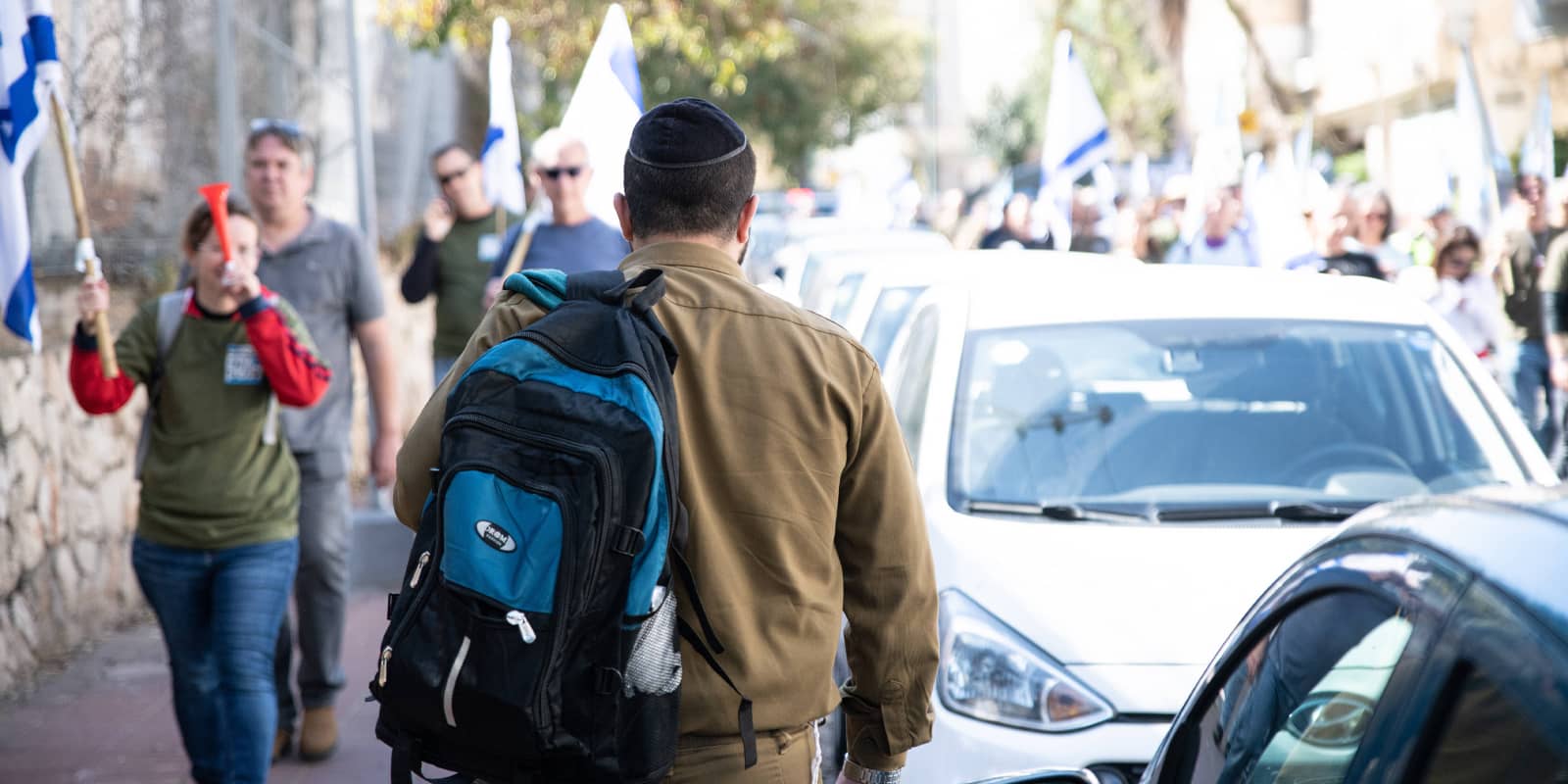 Israeli reserve soldiers protest against the legal reform in Bnei Brak An orthodox soldier in uniforms passes next to the Israeli reserve soldiers protest against the judicial overhaul.