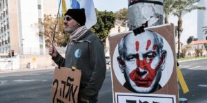 Posters bearing photos of hostages and signs blaming PM Netanyahu