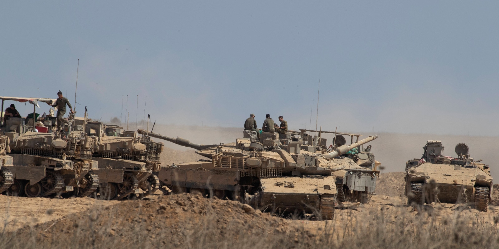 Israeli IDF soldiers worked their tanks in a forward staging area near the Gaza Strip border