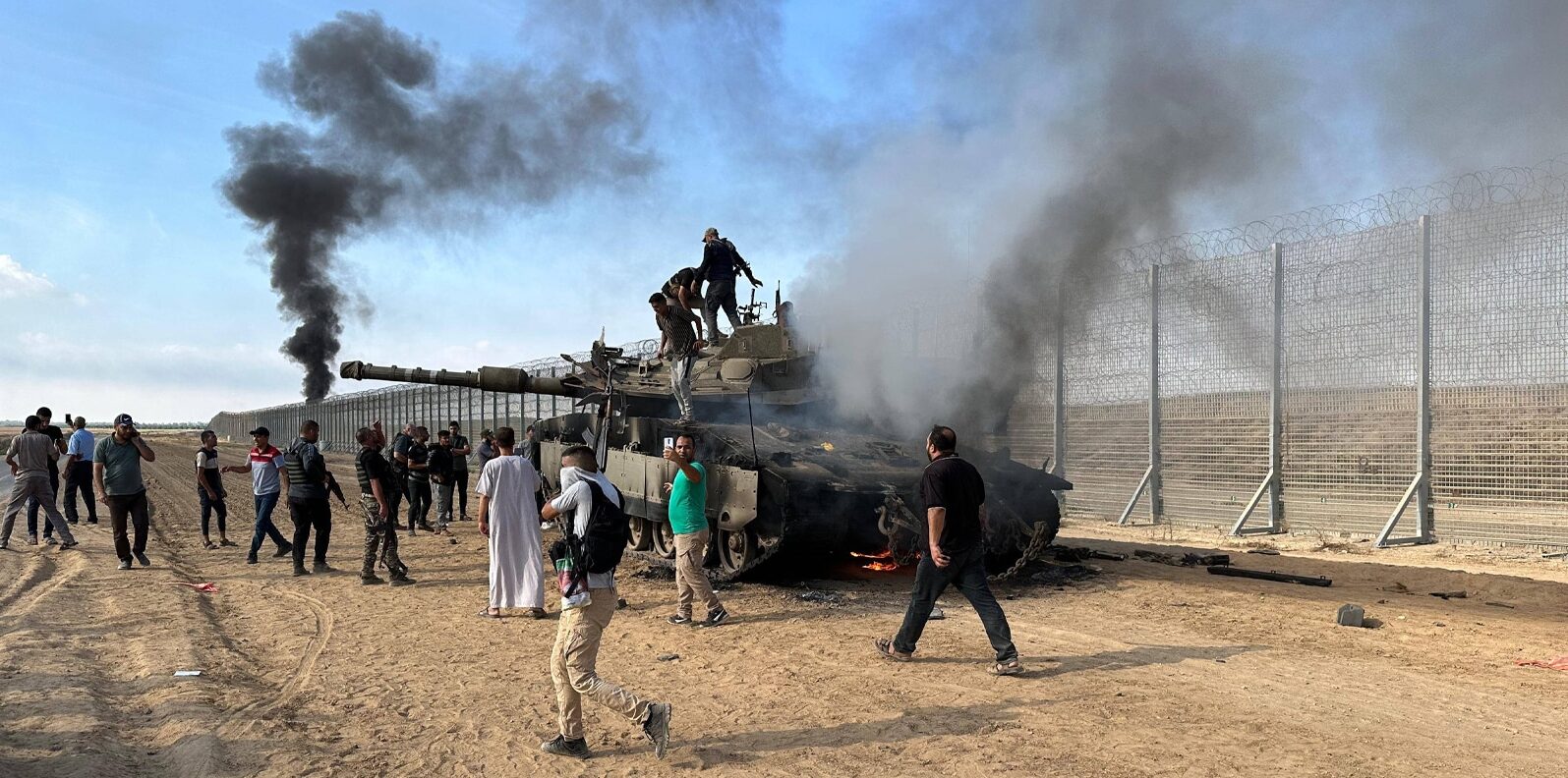 Palestinians burn military armored vehicle belonging to Israeli forces near Gaza Strip, Gaza on October 07, 2023.